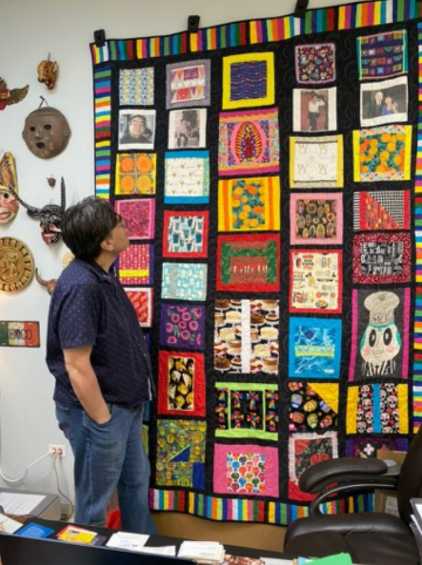 Jose Ochoa admires the quilt on his office wall.